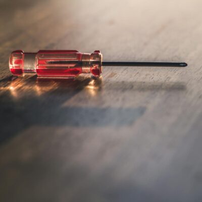 Red Screw Driver on Brown Wooden Surface